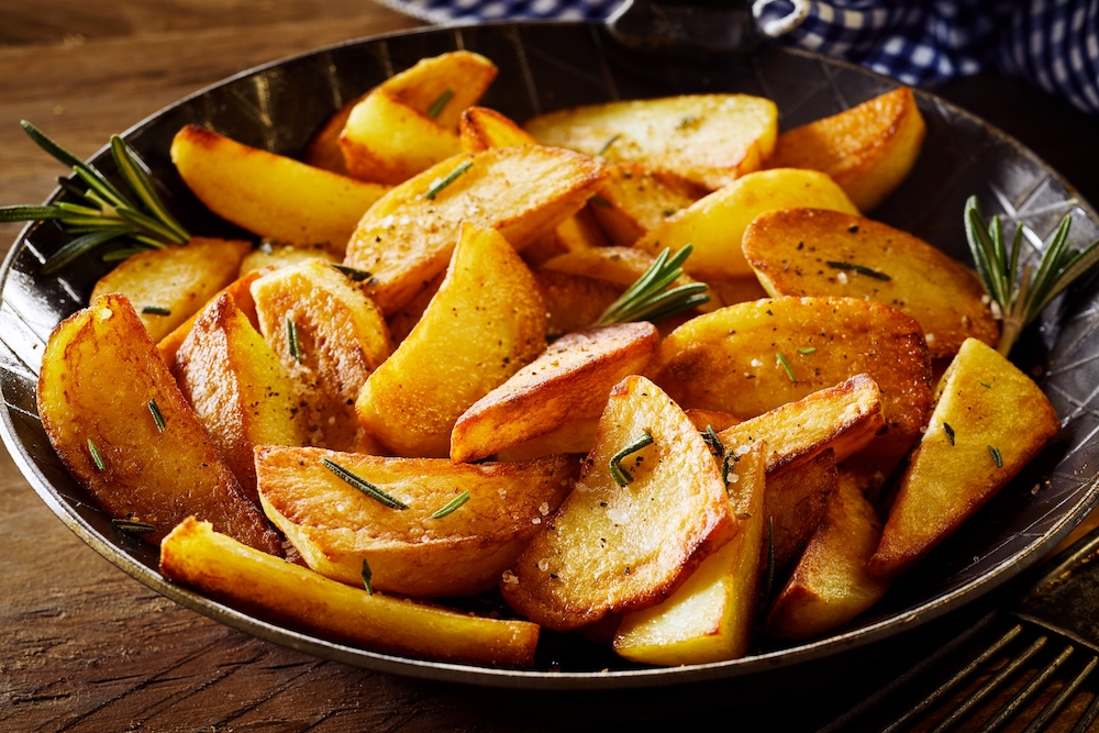 Tasty crispy fried wedges of potato with fresh rosemary