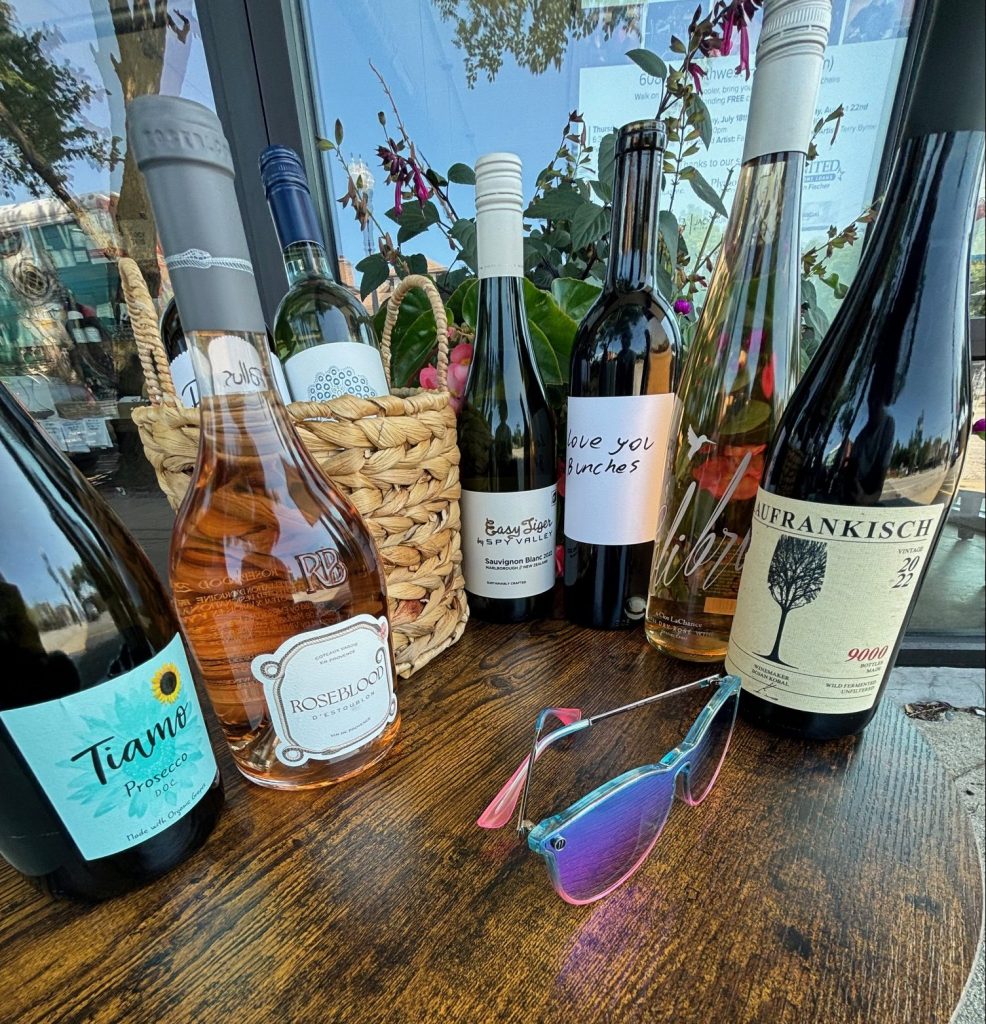 A group of wine bottles on a wooden table.