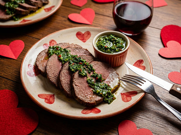 Roast beef chimichurri dish with red wine and valentines day hearts